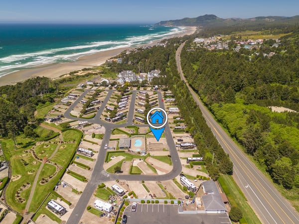Oceanfront RV resort nestled between pristine beach and coastal mountains, surrounded by lush forest and just steps from sandy shores.