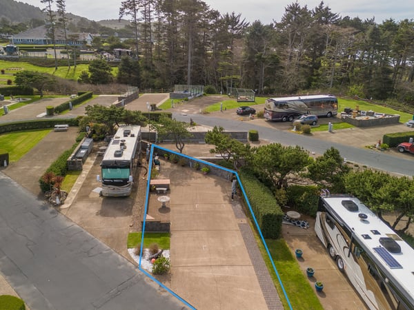 Spacious RV park nestled among coastal trees with mountain views and recreational vehicle accommodations.