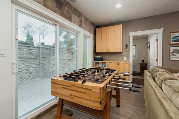 Challenge friends to foosball matches in your bright game room with brick accents and cozy seating.