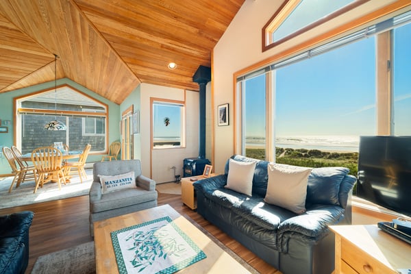 Unwind in your open-concept living space where stunning ocean views frame every moment. Natural wood ceilings and abundant windows create a warm, airy retreat for relaxation.