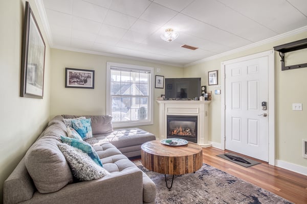 Cozy up in your comfortable living room with a warm fireplace and plush sectional sofa perfect for relaxing evenings.
