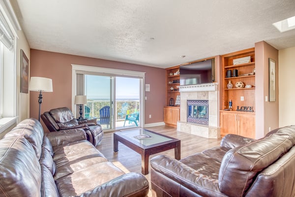 Sink into plush leather seating by your warm fireplace, with stunning natural views from the sliding doors.