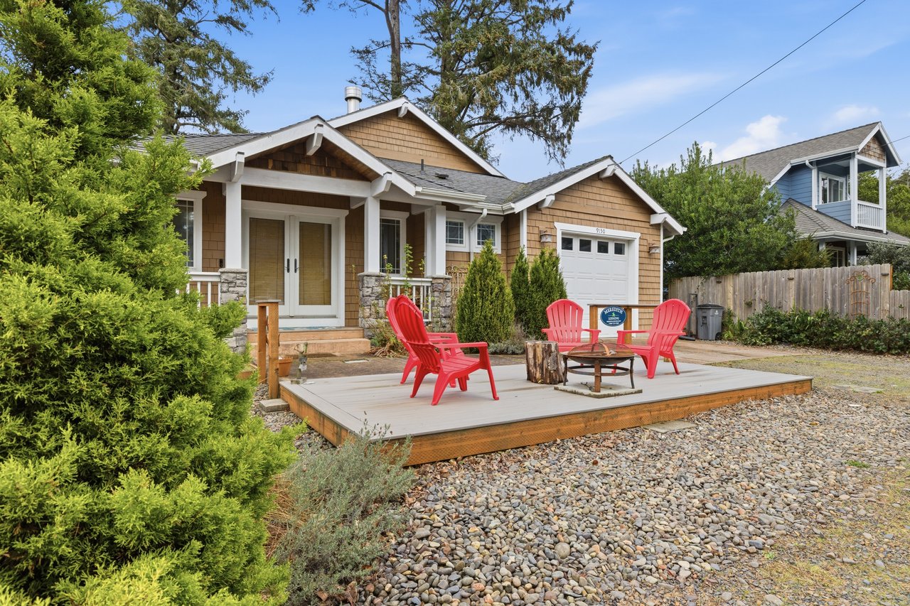 Charming craftsman cottage with your private outdoor deck featuring vibrant red Adirondack chairs—perfect for morning coffee or evening relaxation.