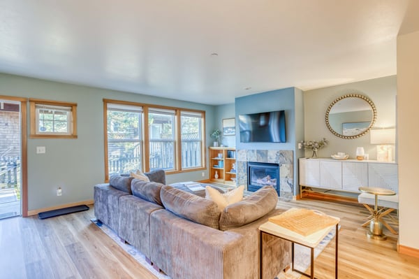 Relax in your bright living room with cozy sectional seating, warm fireplace, and large windows overlooking the neighborhood.