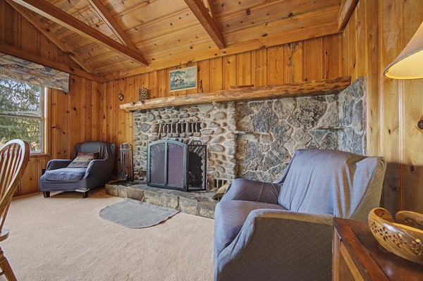 Cozy up in this rustic living room where exposed wooden beams and a magnificent stone fireplace create your perfect mountain retreat.