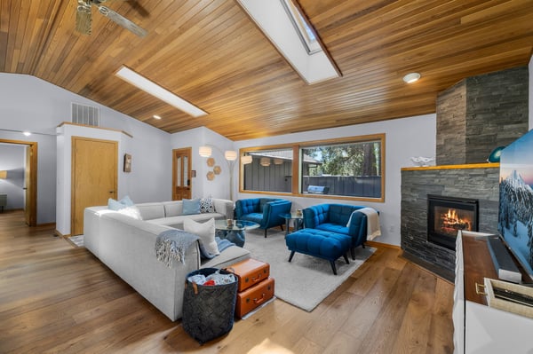 Unwind in your expansive living room where vaulted wood ceilings and a stone fireplace create mountain-modern comfort. Plush seating, skylights, and serene views invite you to relax after your adventures.