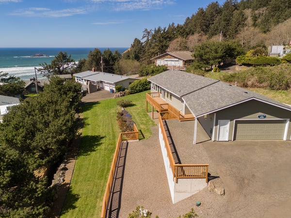 Coastal retreat with ocean views, spacious deck, and direct beach access in a peaceful wooded setting.