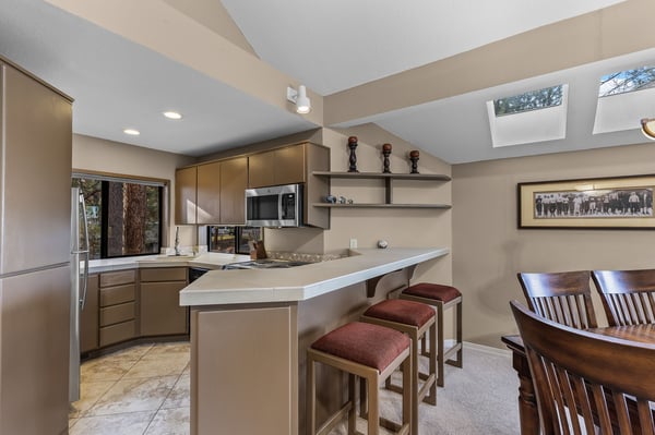 Cook your favorite meals in this bright, modern kitchen with sleek countertops, premium appliances, and cozy breakfast bar seating.