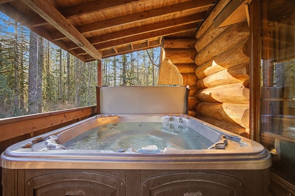 Soak in your private hot tub surrounded by rustic log cabin charm and peaceful forest views.