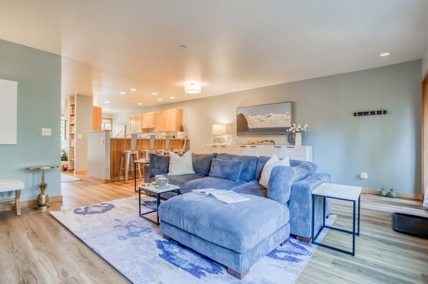 Sink into the plush blue sectional and feel instantly at home in this airy open-plan space where modern comfort meets coastal charm.