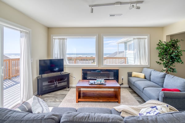 Unwind in your spacious living room with stunning ocean views, cozy fireplace, and comfortable seating perfect for relaxing evenings.