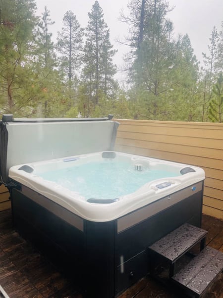 Sink into warm bubbling waters while gazing at the peaceful forest canopy—your private hot tub sanctuary awaits.