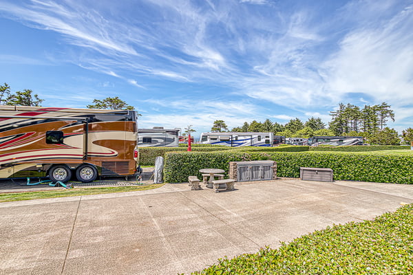 The property features a private paved patio area with outdoor seating and manicured hedges, offering a peaceful outdoor space for relaxation.