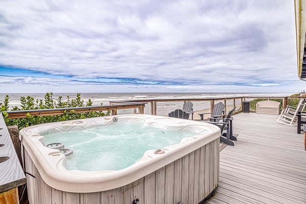 Soak in the bubbling hot tub while gazing at endless ocean views and feel the gentle sea breeze refresh your senses on this expansive beachfront deck.