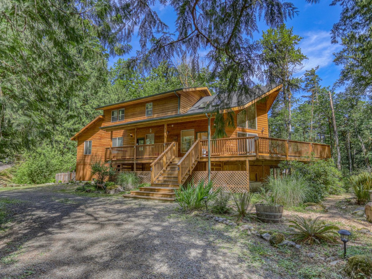 A welcoming timber lodge nestled among towering trees, offering peaceful seclusion and easy access to natural surroundings. The spacious wrap-around deck provides a perfect spot for morning coffee or evening relaxation.