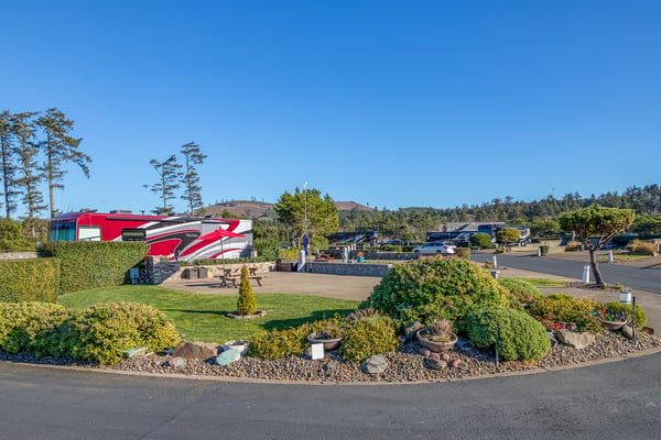 Coastal RV park with manicured landscaping and mountain backdrop offers a scenic retreat setting.
