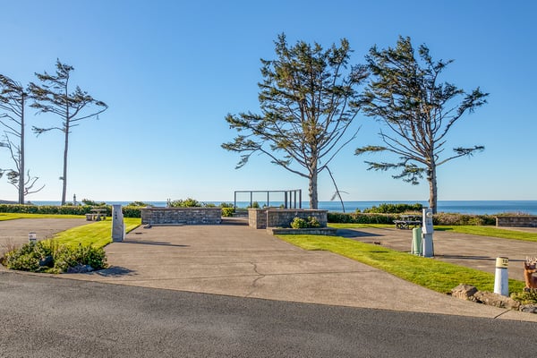 Ocean-front location with sweeping sea views and mature trees creating a serene coastal setting for this property.