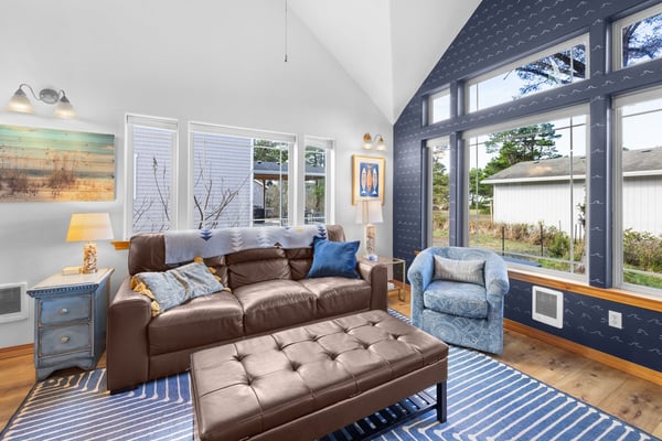Sink into plush leather seating while natural light floods through expansive windows in your cozy retreat.