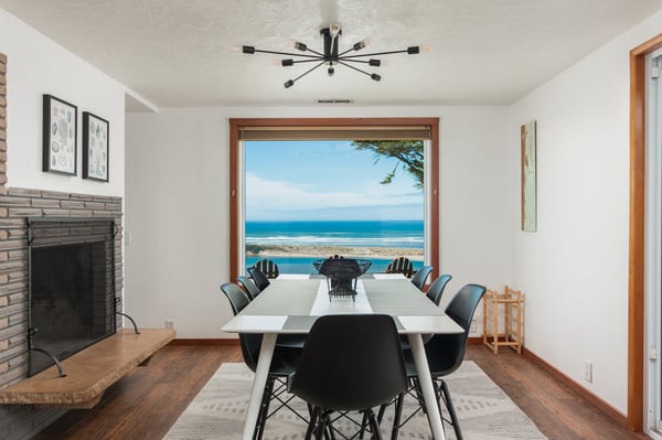 Your dining space frames stunning ocean views through floor-to-ceiling windows, creating the perfect backdrop for memorable meals with loved ones.