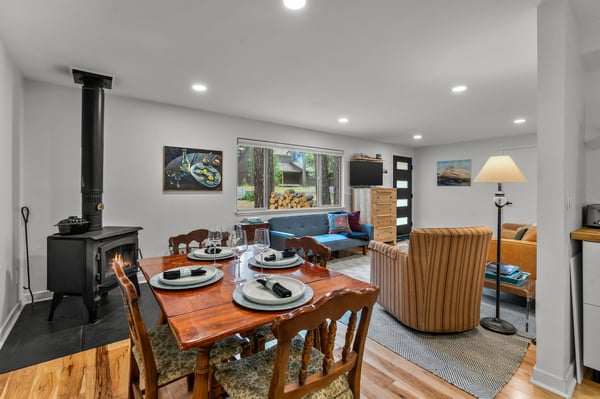 You'll love gathering here—an open space where dining and relaxation blend effortlessly. The wood-burning stove adds warmth while you enjoy meals together at the welcoming table.