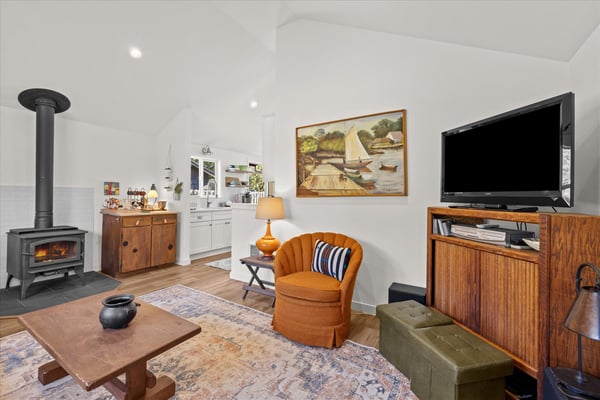 Cozy up by your crackling fireplace while enjoying modern comforts like the flat-screen TV in this stylish living space.