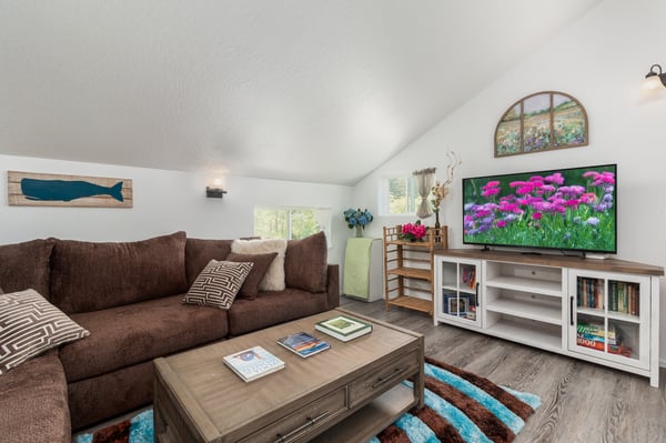 Sink into the plush sofa and unwind beneath vaulted ceilings in this bright, airy living space complete with charming coastal décor and entertainment for your entire stay.