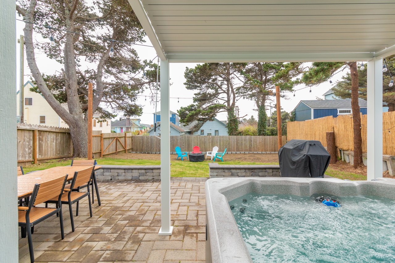 Soak in your private hot tub under the covered patio while enjoying views of the peaceful backyard and colorful neighborhood beyond.
