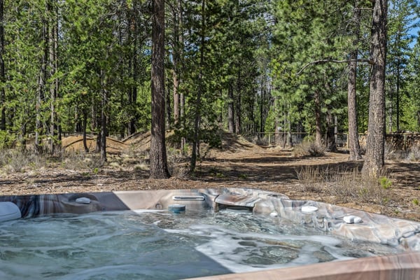 Soak in your private hot tub surrounded by towering pines, where forest tranquility meets bubbling warmth for the perfect mountain retreat.