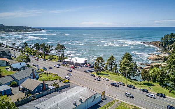 A stunning coastal location where rugged cliffs meet turquoise waters, with the Pacific Ocean stretching to the horizon. The scenic oceanfront area features sandy beaches and dramatic rock formations.