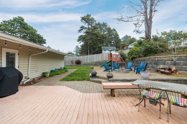 Your private backyard oasis features a spacious deck, fire pit with cozy seating, and grassy lawn perfect for family gatherings.