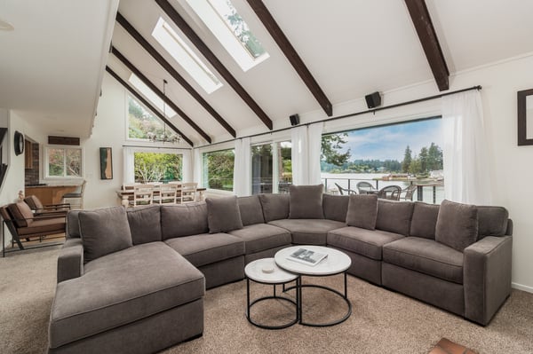 Sink into this spacious sectional and let natural light pour through the vaulted ceiling and skylights while you gaze at the waterfront view beyond your deck.