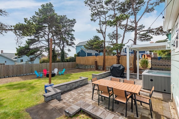 Relax in your private backyard oasis with hot tub, outdoor dining, and colorful Adirondack chairs on spacious lawn.