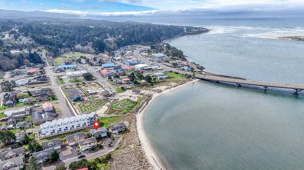 Coastal community surrounded by forested hills and pristine waters, offering a peaceful seaside retreat location.
