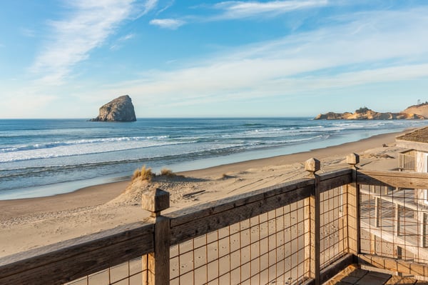 Stunning Pacific coastline with dramatic sea stack and pristine sandy beach just steps from the property entrance.