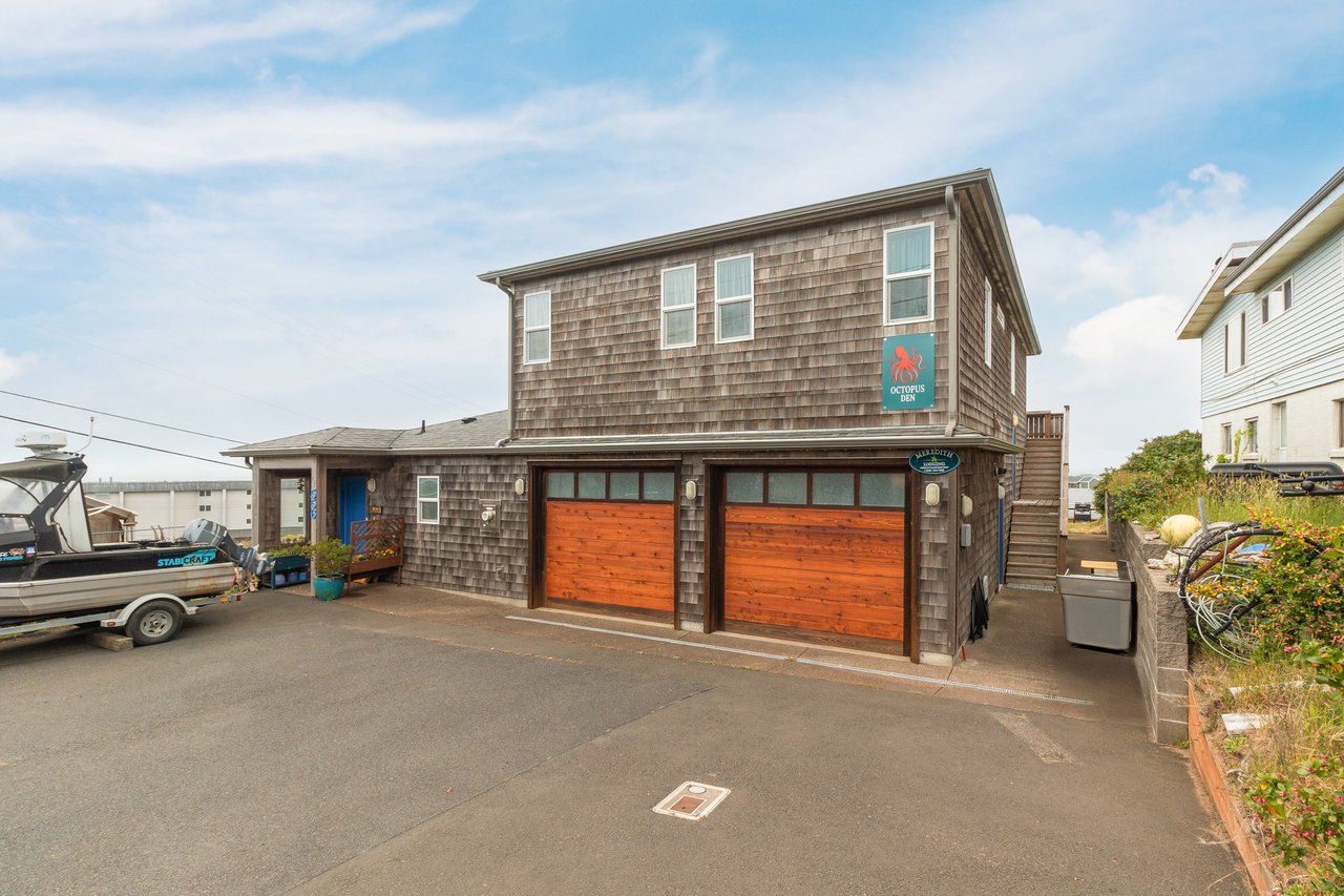 Coastal retreat with shingled exterior, two-car garage, and parking located steps from the waterfront in a friendly neighborhood setting.