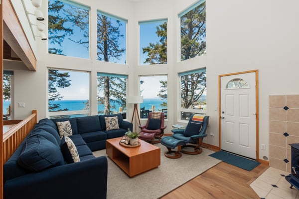 Sink into the navy sectional and let the stunning sea views through floor-to-ceiling windows wash over you in this bright, airy living space.