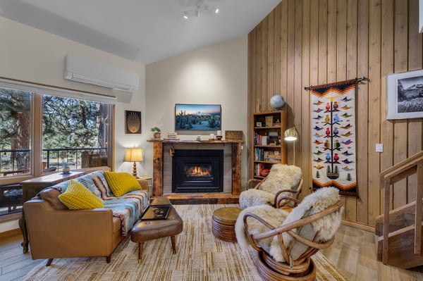 Cozy up in your personal retreat with a crackling fireplace, plush seating, and warm wood accents. Sunlight streams through large windows, while unique touches like vintage ski décor add mountain charm.