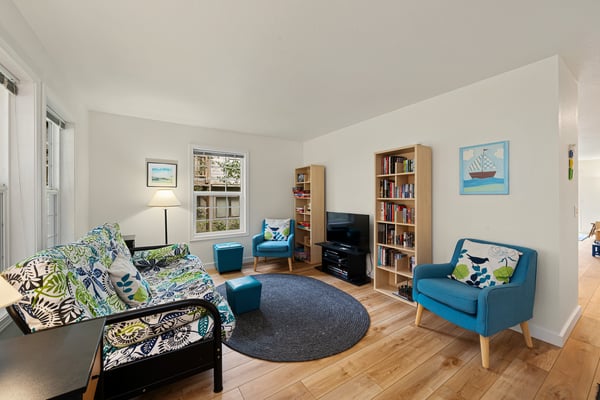 Settle into this bright, cheerful living space with plush seating, books for every mood, and cheerful pops of blue and green inviting you to unwind completely.