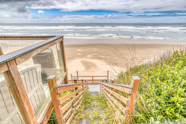 A private beach access pathway leads from the property through coastal dunes to pristine sandy shores and inviting waves.