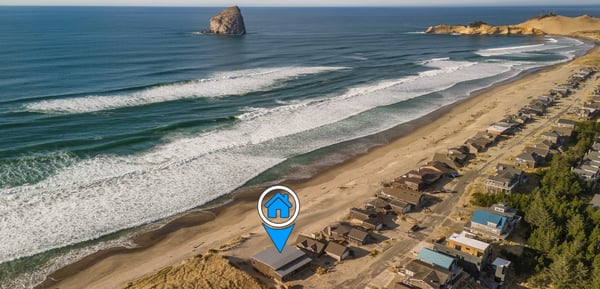 Stunning oceanfront property location with pristine sandy beach and dramatic coastal rock formations nearby.