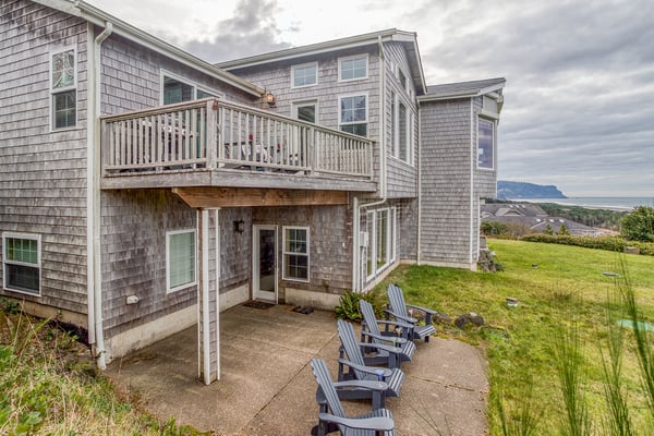 Charming coastal property featuring classic cedar shingle siding, spacious balcony, and sweeping views of the surrounding landscape and distant mountains.