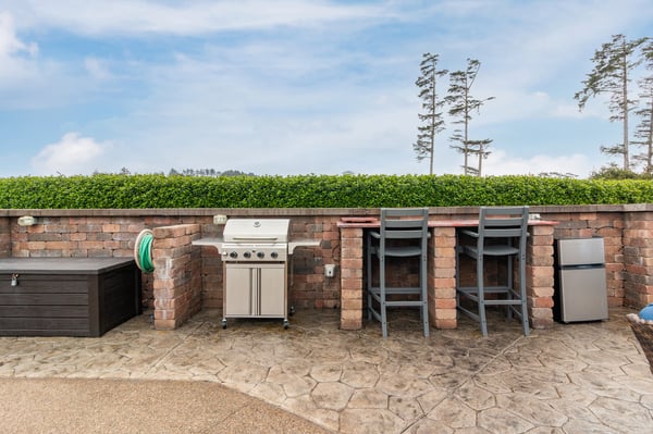 Private patio features a full-size grill, bar seating, and mini fridge—your perfect spot to savor sunny meals and evening drinks outdoors in complete comfort.