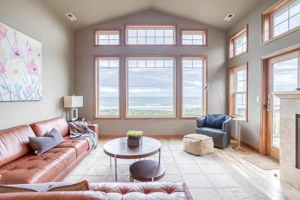 Sink into plush leather seating while ocean views frame your perfect getaway through soaring windows in this bright, airy living space.