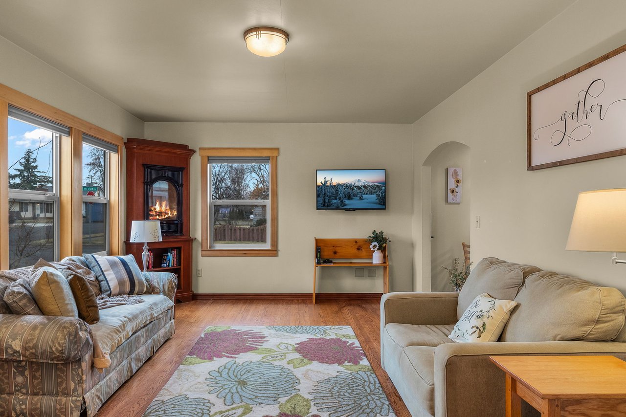 Cozy up by your crackling fireplace in this inviting living room, where plush sofas and mountain views create perfect moments for relaxation.