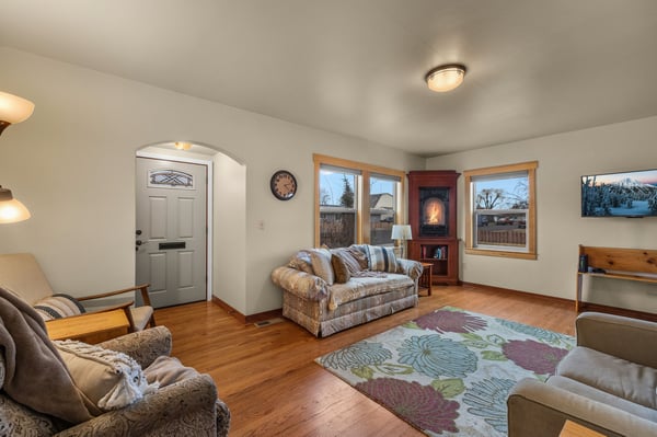 Cozy up in this inviting living room with plush seating, warm fireplace, and charming hardwood floors that welcome you home.