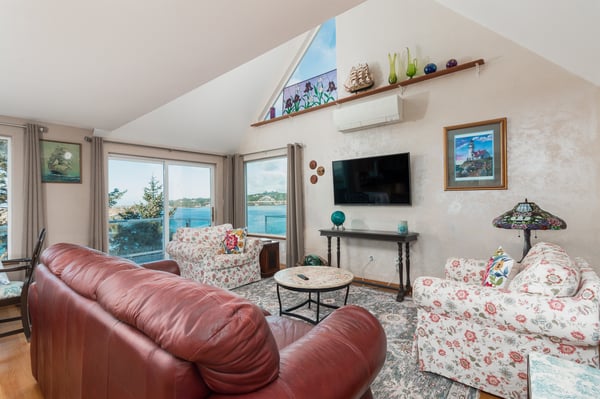 Relax in your bright, coastal-inspired living room with stunning water views through picture windows and comfortable seating for the whole family.