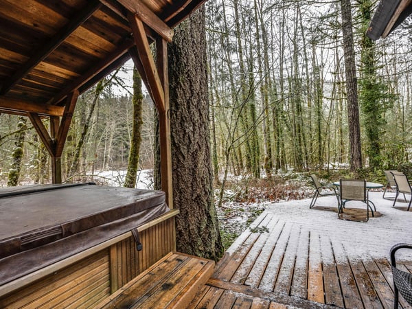 Soak in your private hot tub while snow dusts the serene forest around you, creating the perfect winter retreat.