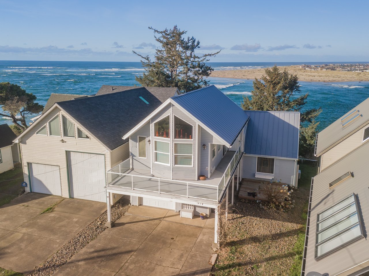 Stunning oceanfront property with elevated deck showcasing breathtaking Pacific coastline views and pristine sandy beaches.