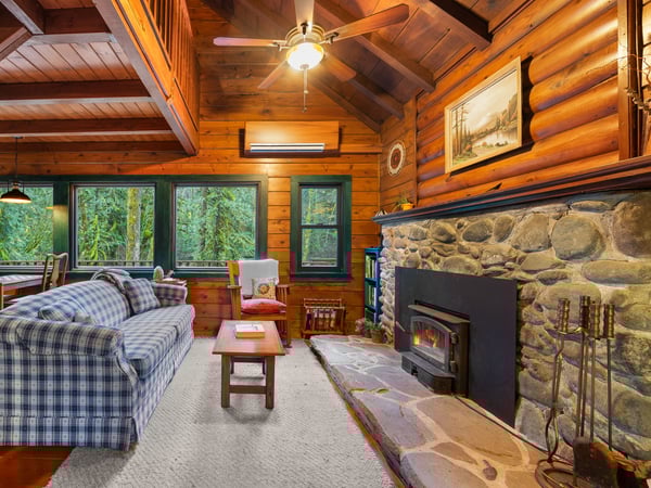 Cozy up in your rustic retreat with exposed beam ceilings, stone fireplace, and forest views through every window.